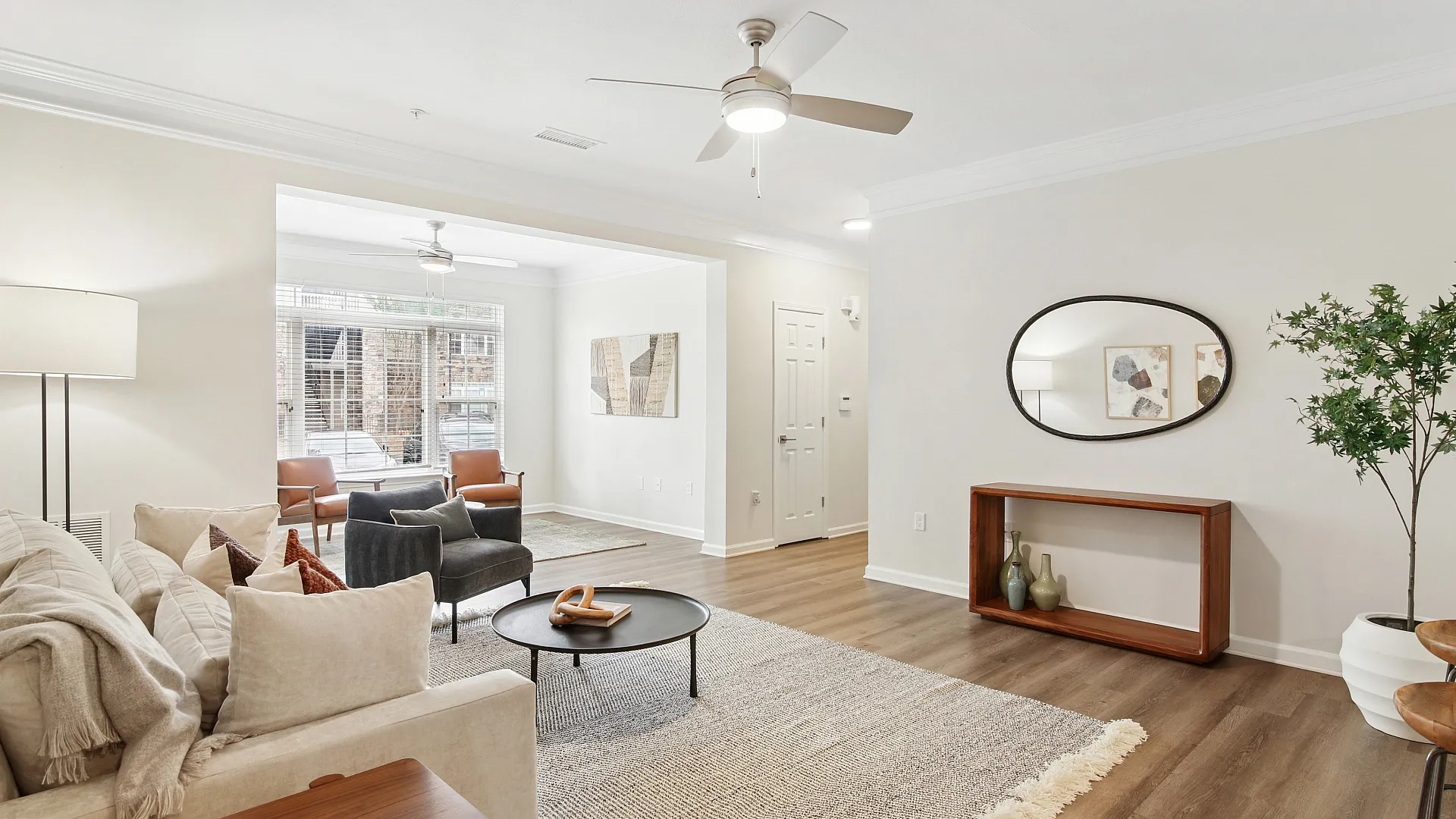 Elegant living room with cozy beige sofa, modern decor, and abundant natural light, creating a warm and inviting atmosphere.