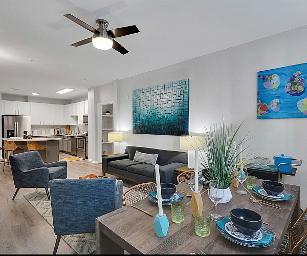Contemporary open-plan living area with stylish furnishings, featuring a modern kitchen, elegant dining space, and cozy lounge with vibrant artwork.