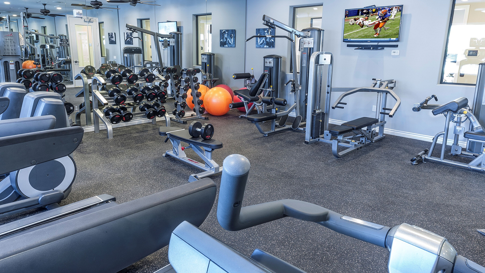 Modern gym with state-of-the-art fitness equipment, mirrored walls, and bright lighting for an energizing workout experience.