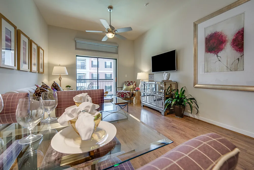Inviting living room with chic decor, featuring a cozy sofa, modern art, and large windows offering a beautiful view.