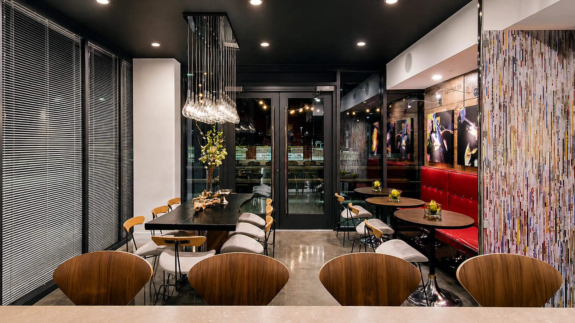 Chic dining area with elegant wooden chairs, contemporary lighting, and artistic decor creating a cozy ambiance.