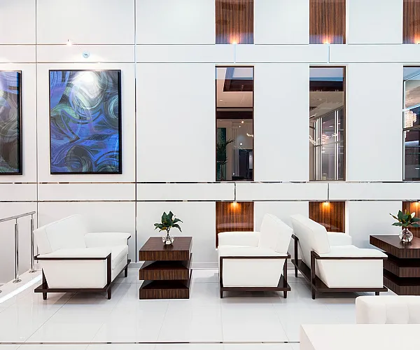 Sophisticated living area boasting modern white seating, elegant wood accents, and artistic wall decor in a chic open floor plan.