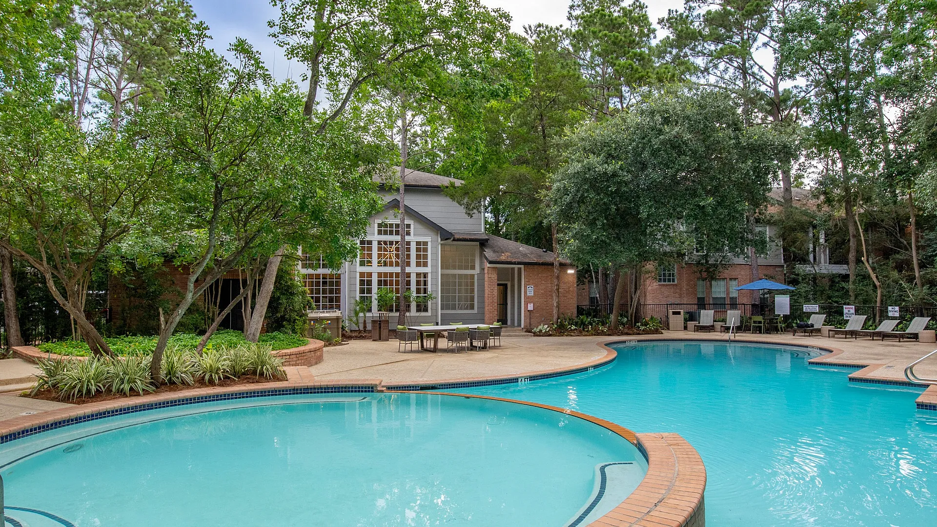 Inviting outdoor swimming pool surrounded by lush greenery and comfortable lounge chairs, perfect for a relaxing retreat.