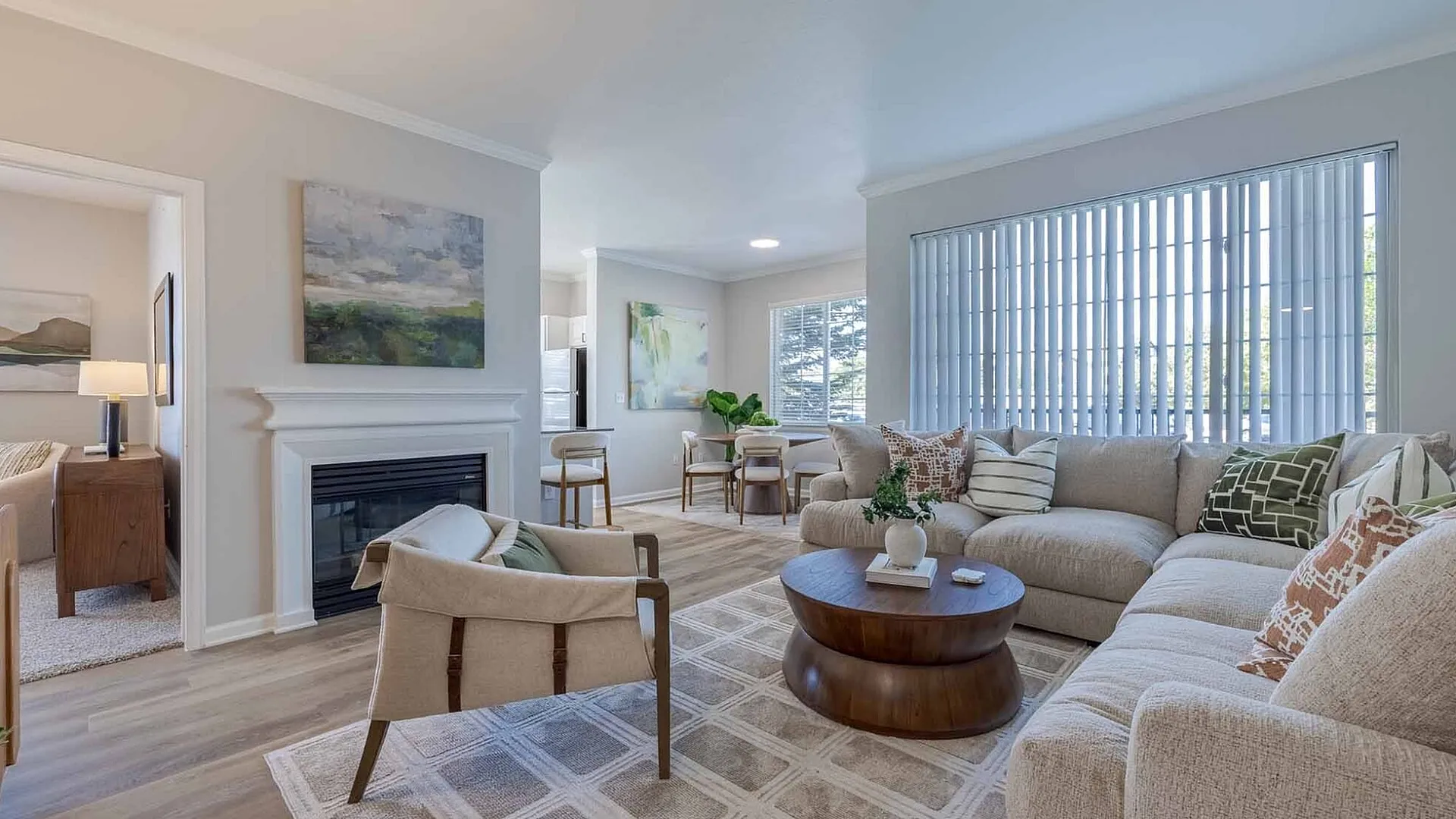 Bright and inviting living room with a cozy sectional sofa, elegant fireplace, and large window offering ample natural light, perfect for relaxation and entertaining.