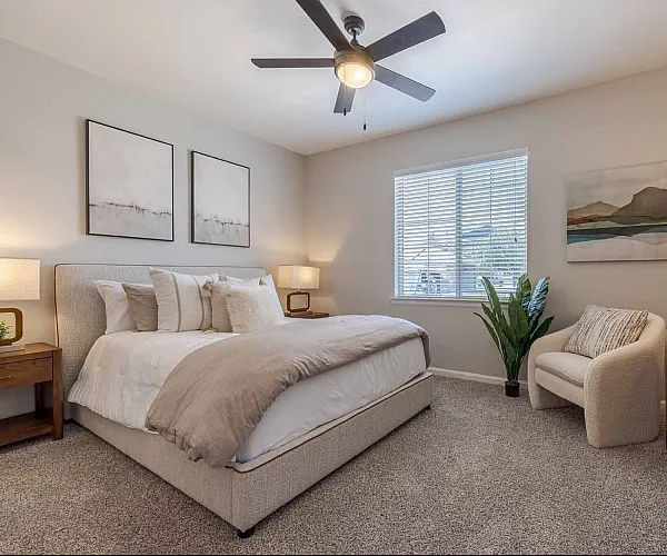 Inviting bedroom with a plush bed, elegant decor, and ample natural light creating a serene atmosphere.