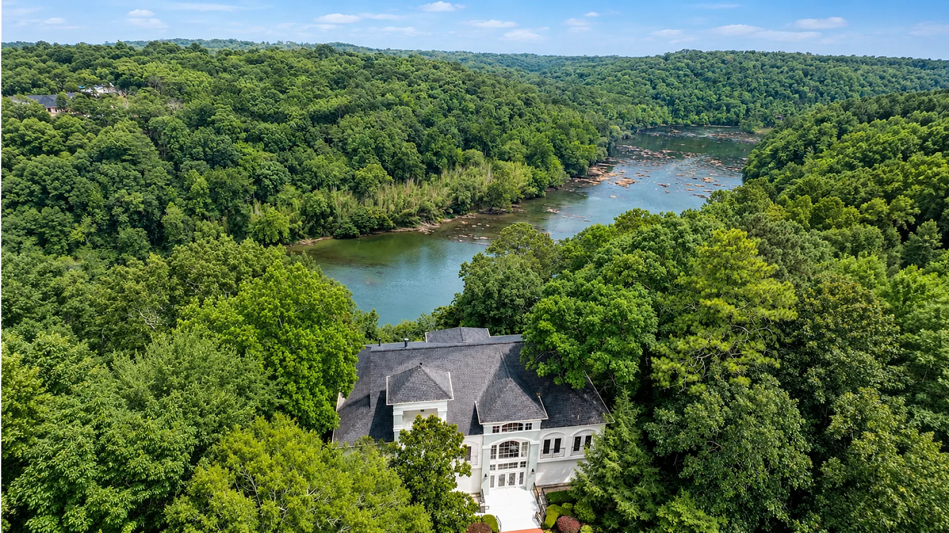 Breathtaking riverside estate surrounded by lush greenery, offering serene views and a secluded retreat.
