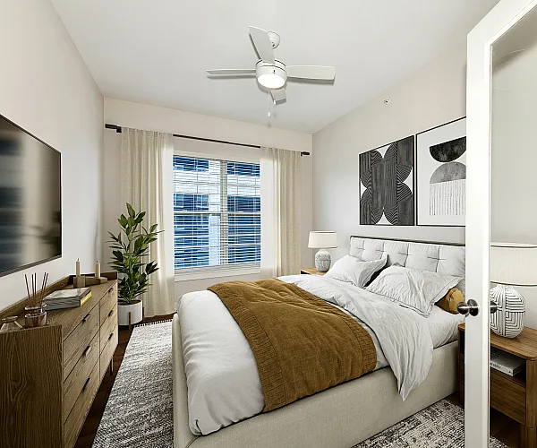 Modern bedroom with stylish decor, featuring a comfortable bed, elegant wall art, large window, and a sleek ceiling fan, creating a cozy and inviting atmosphere.