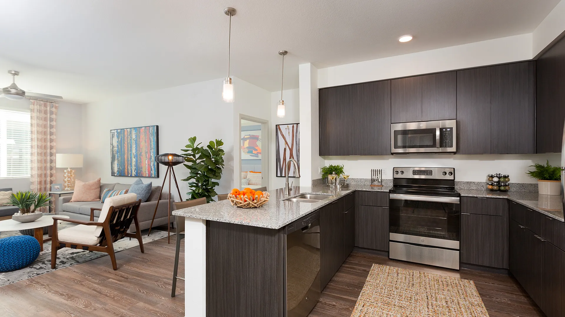 Modern open-concept kitchen and living room with sleek cabinetry, stainless steel appliances, and stylish decor, perfect for entertaining and relaxation.