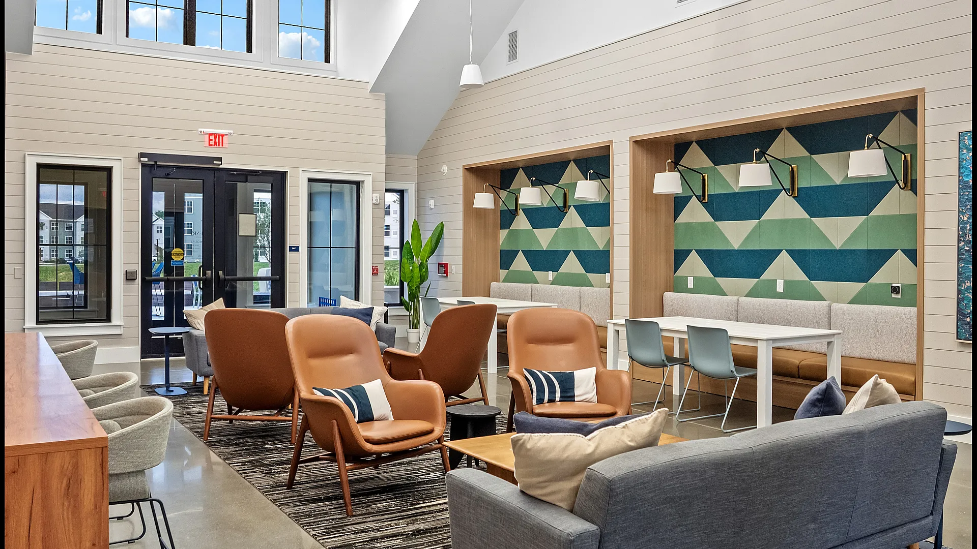 Chic lounge area with modern seating, vibrant geometric wall designs, and natural lighting from large windows.