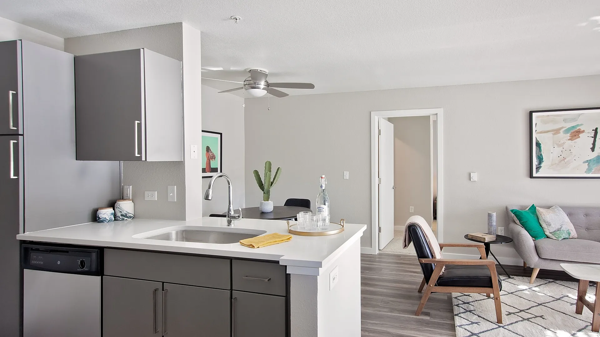 Modern open-concept living space featuring a sleek kitchen with stainless steel appliances, cozy living area with stylish furniture, and ample natural light.