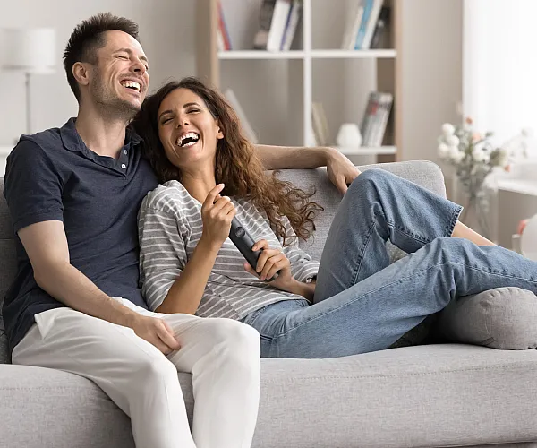 Modern living room with a cozy atmosphere, featuring a comfortable gray sofa, bright natural light, and elegant decor.