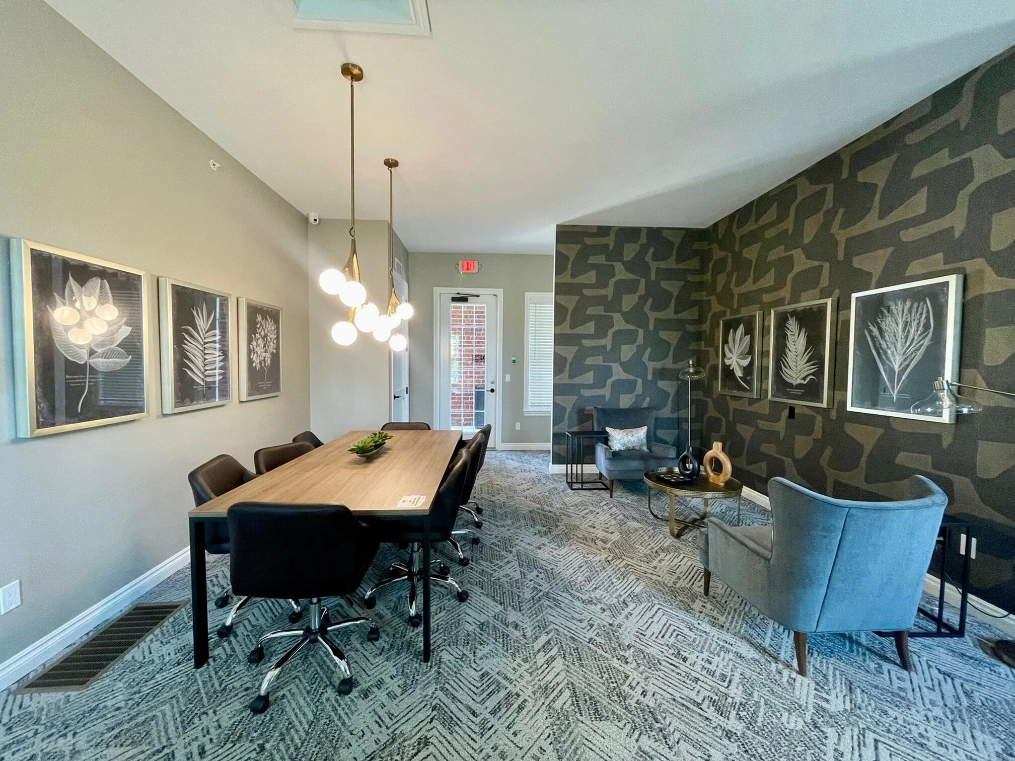 Modern meeting room showcasing elegant decor, featuring a sleek wooden conference table, chic chairs, and stylish geometric wallpaper for a sophisticated ambiance.