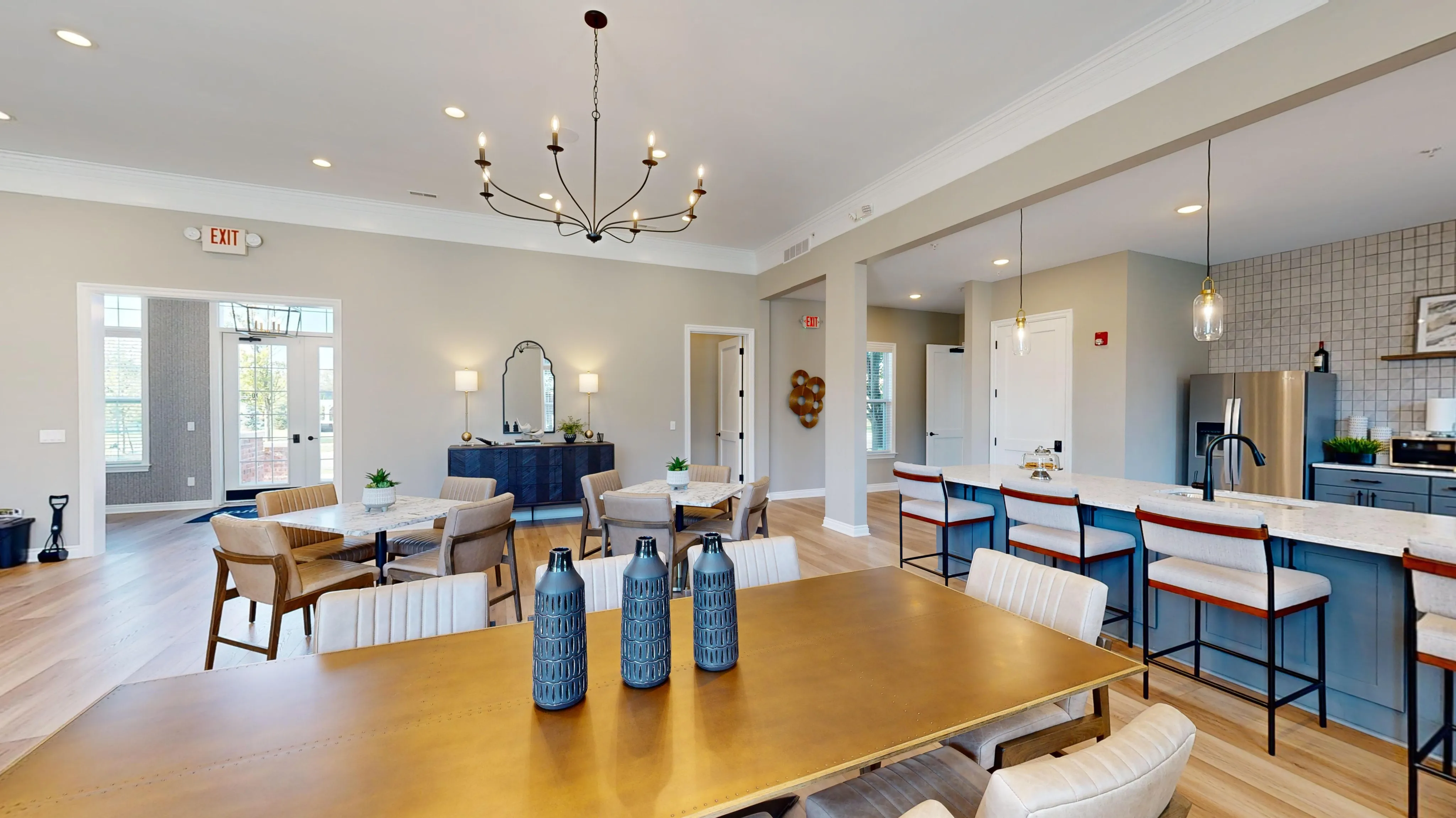 Elegant open-concept living space featuring a chic dining area, modern kitchen with a breakfast bar, and stylish lighting fixtures.
