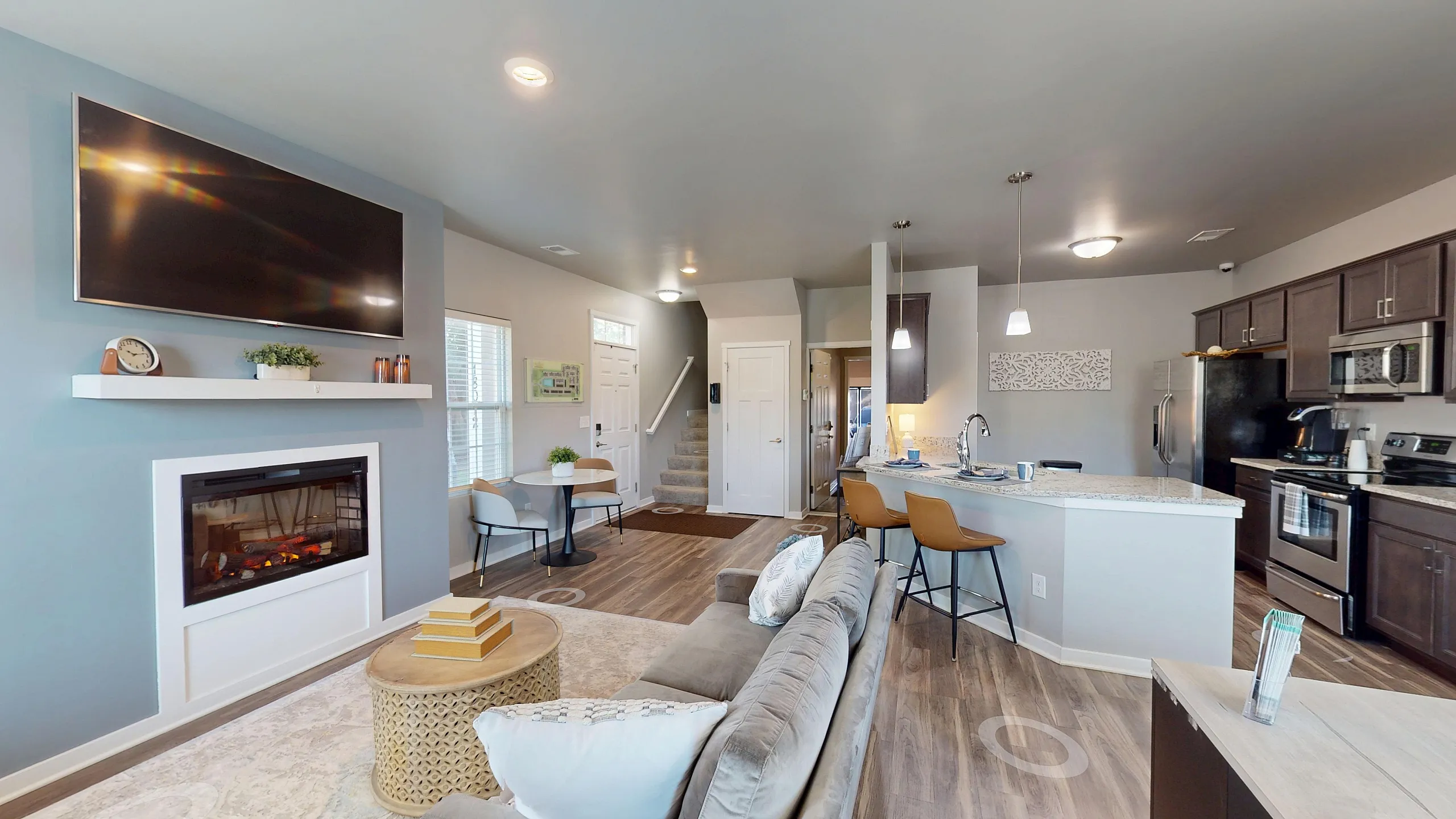 Chic open-concept living area with modern kitchen, cozy fireplace, and stylish decor, perfect for entertaining.