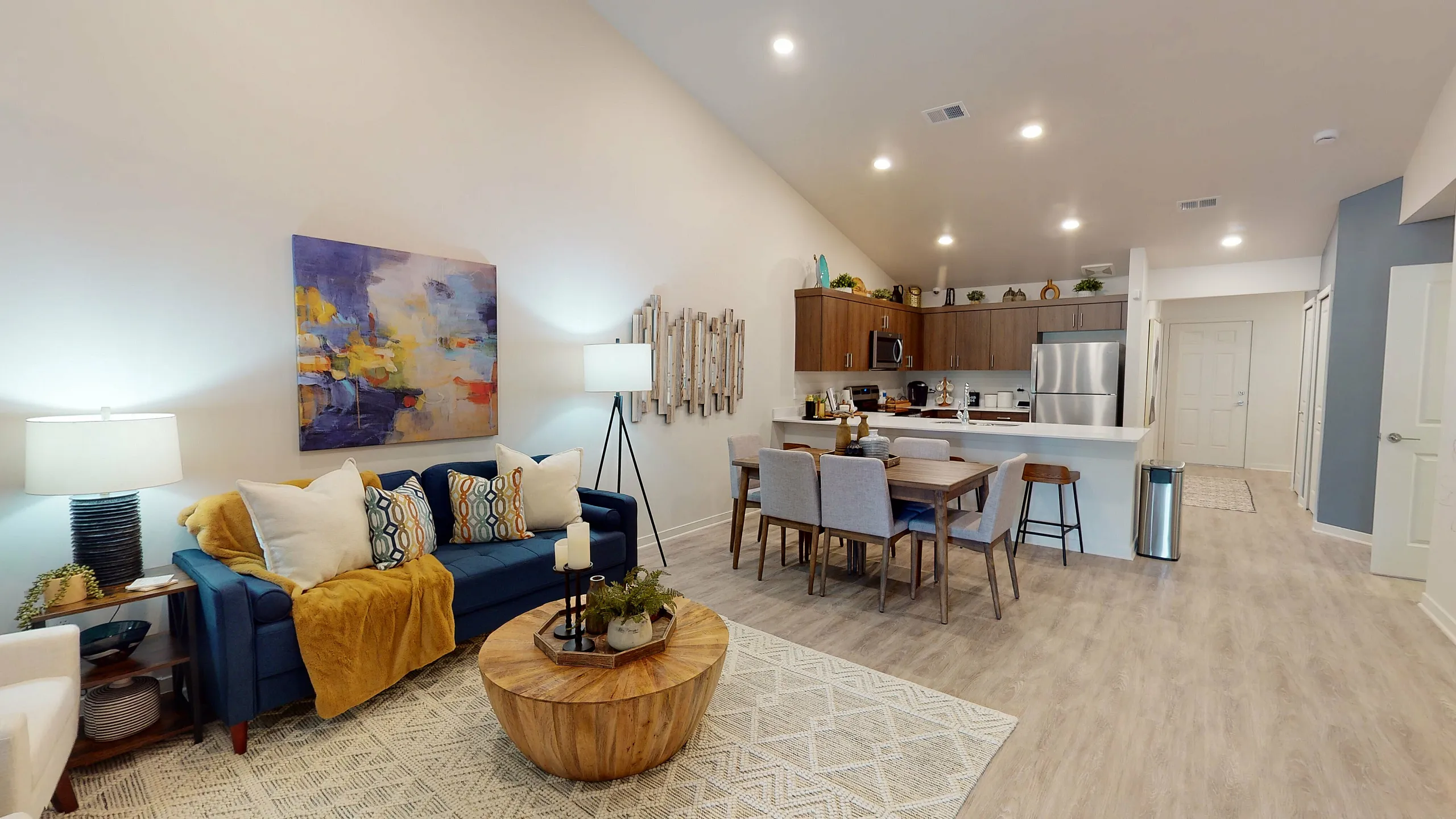 Chic open-concept living room with stylish decor, cozy seating, and modern kitchen with sleek appliances.