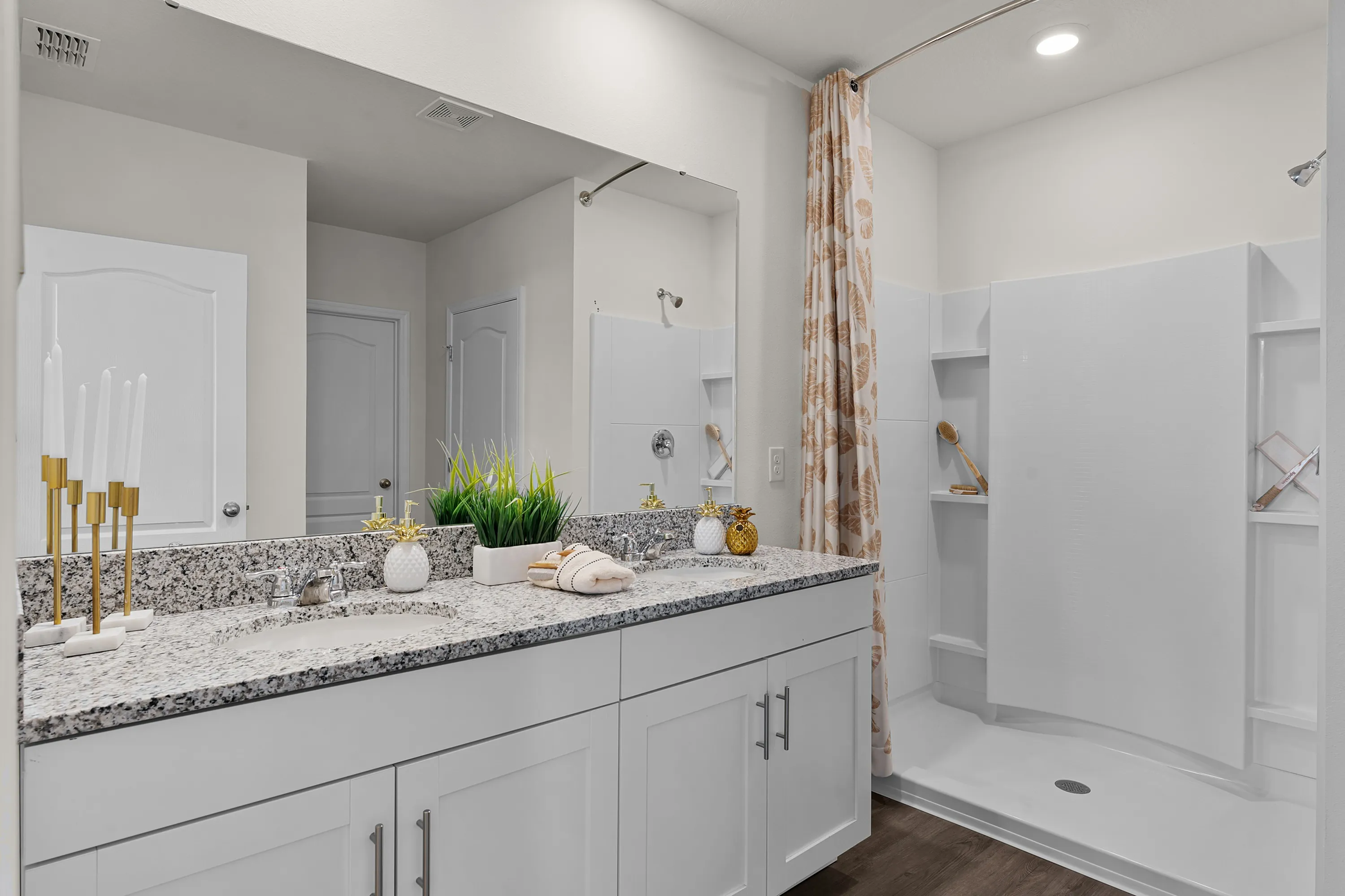 Bright and spacious bathroom with dual-sink vanity and walk-in shower.