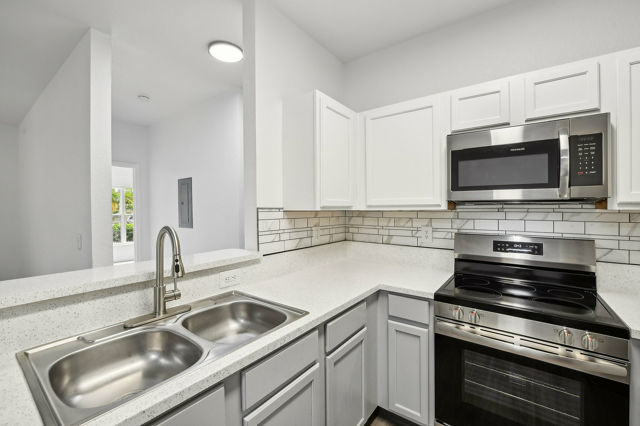 interior pic of deluxe kitchen unit with gray planking and white walls, stainless steel appliances and backsplash