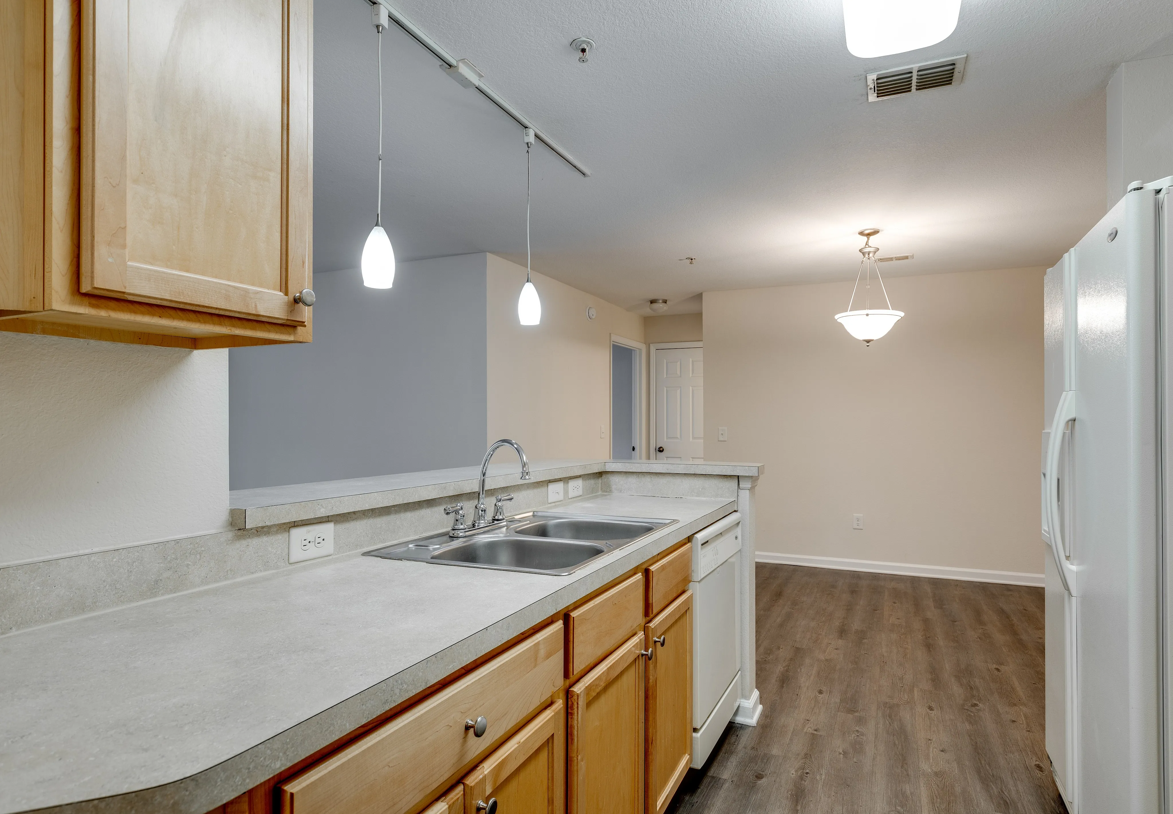 Modern kitchen with bar seating and pendant lighting.