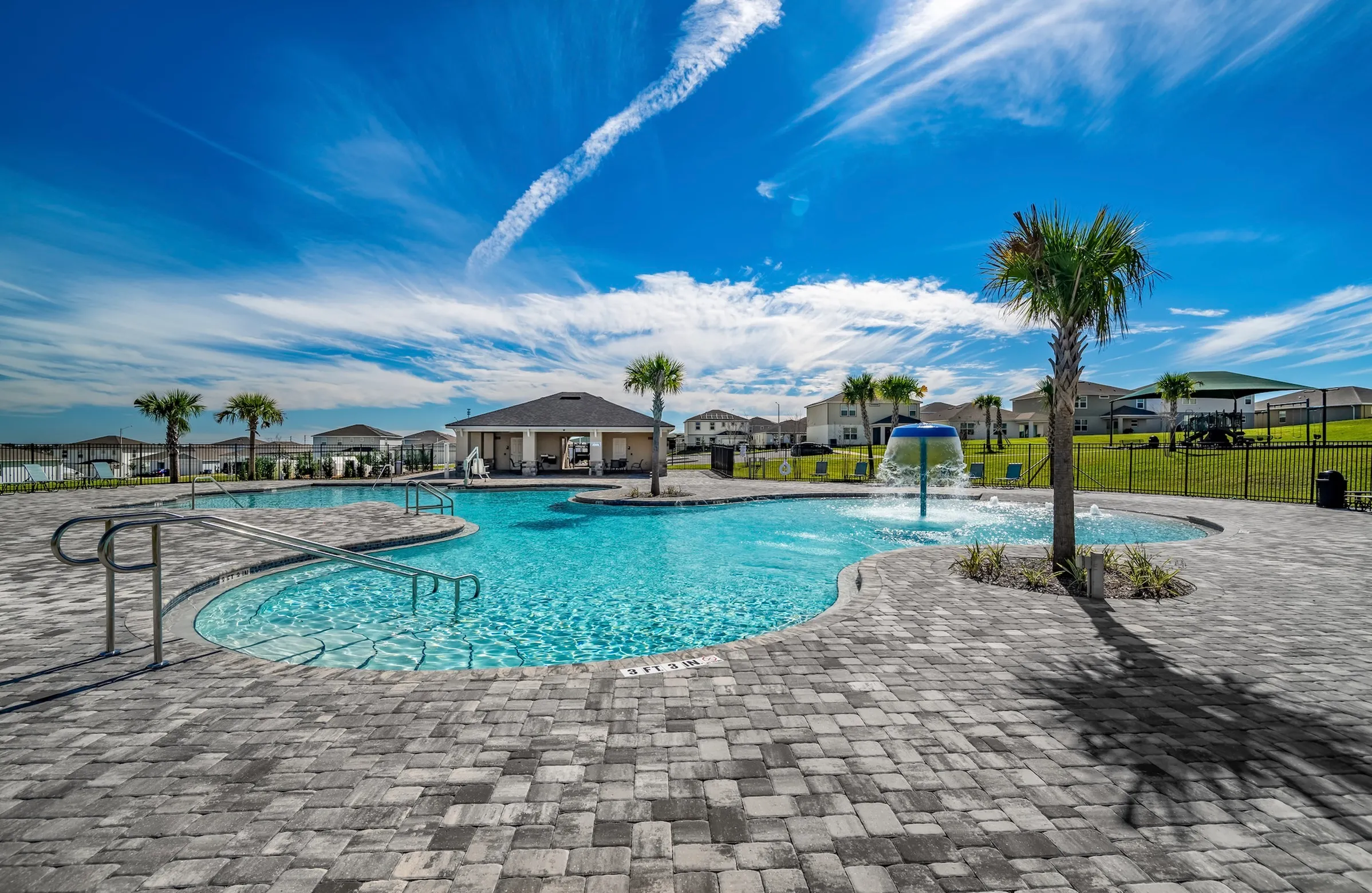 Expansive community pool with splash features and open-air seating.