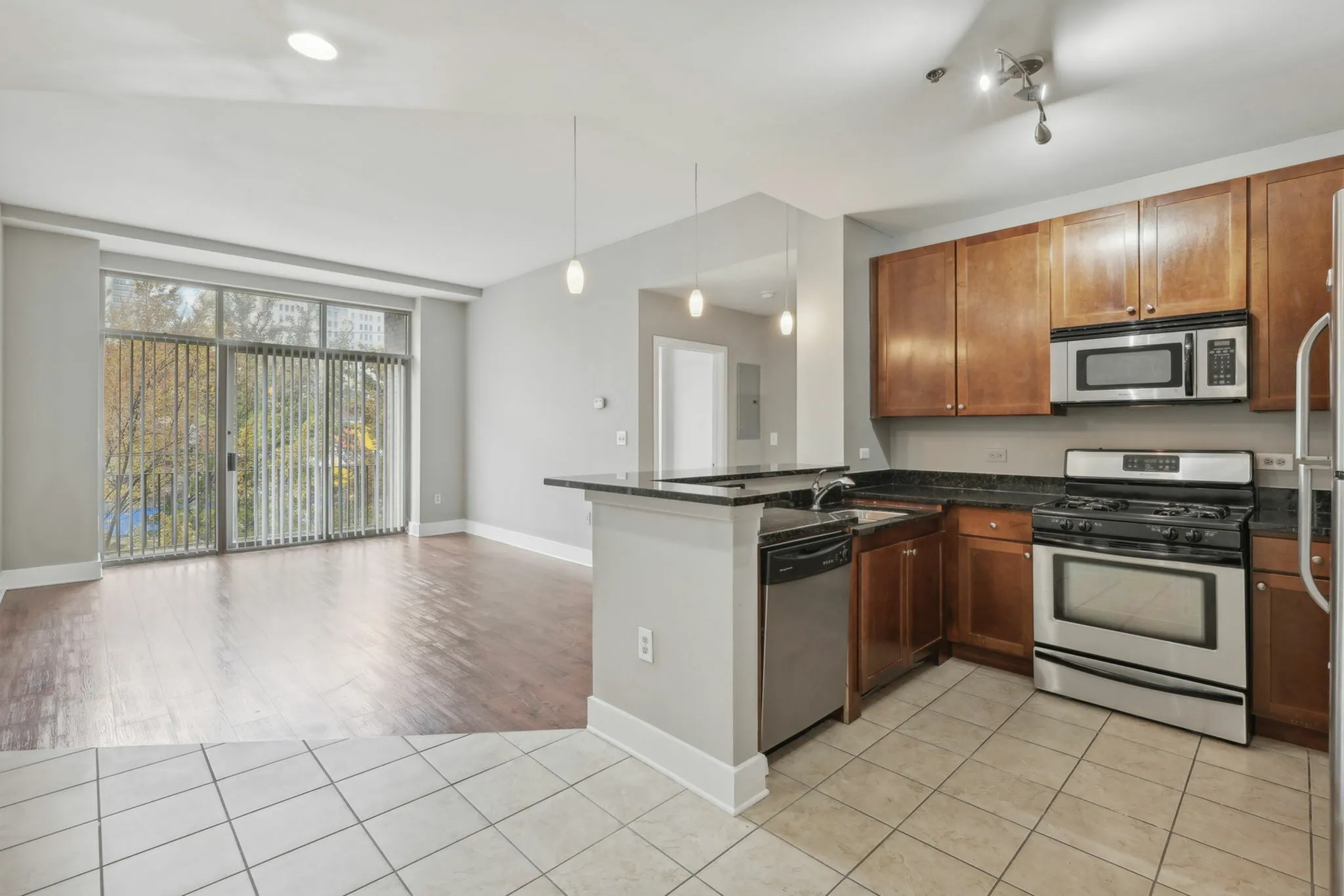 Open-concept kitchen with stainless steel appliances and bar counter
