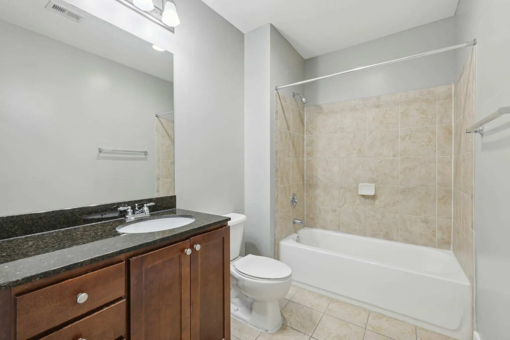 Bathroom with granite vanity and tiled shower-tub combo