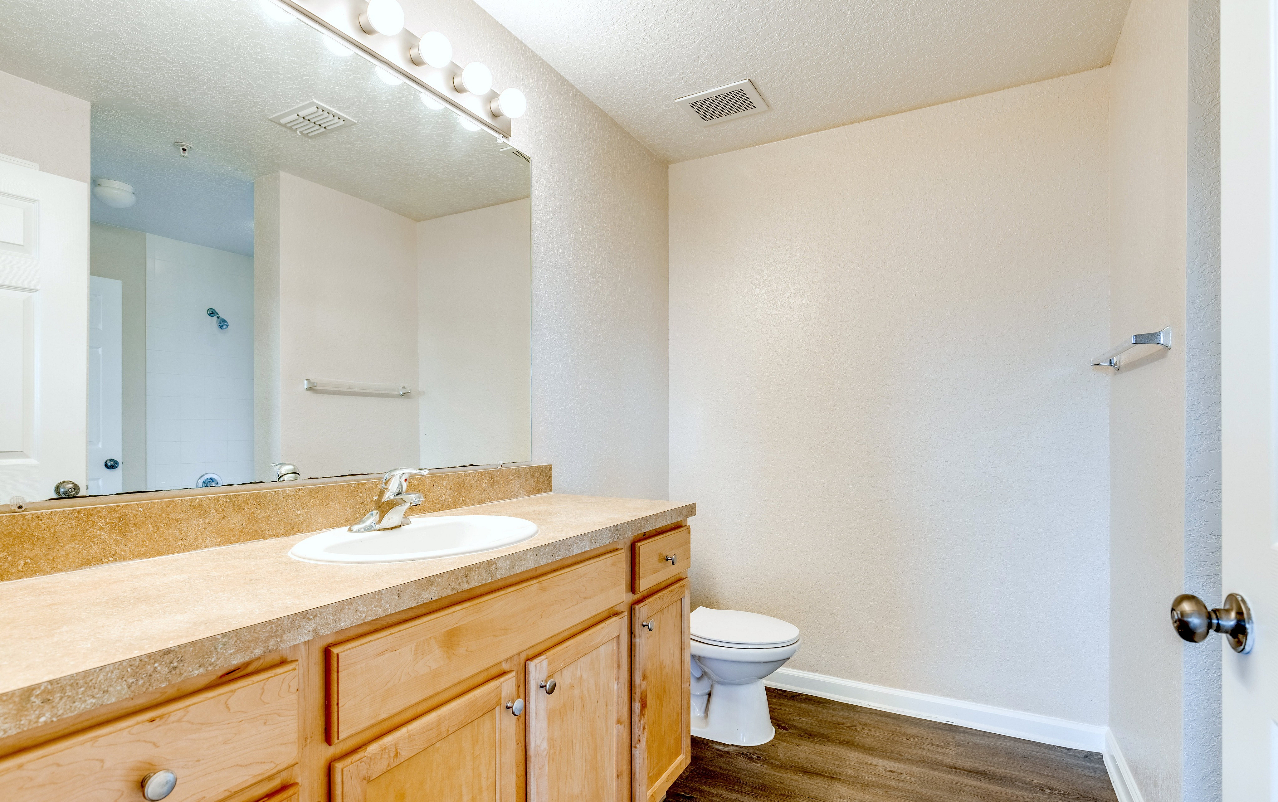 Spacious bathroom with large vanity and mirror.