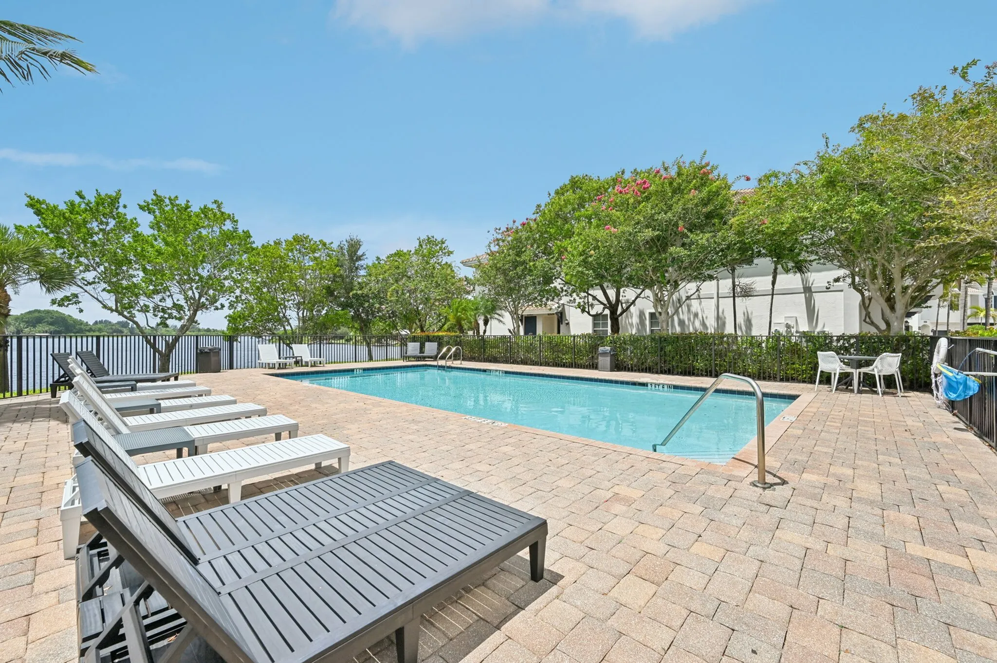 Inviting outdoor pool area with comfortable loungers, surrounded by lush greenery and serene views.