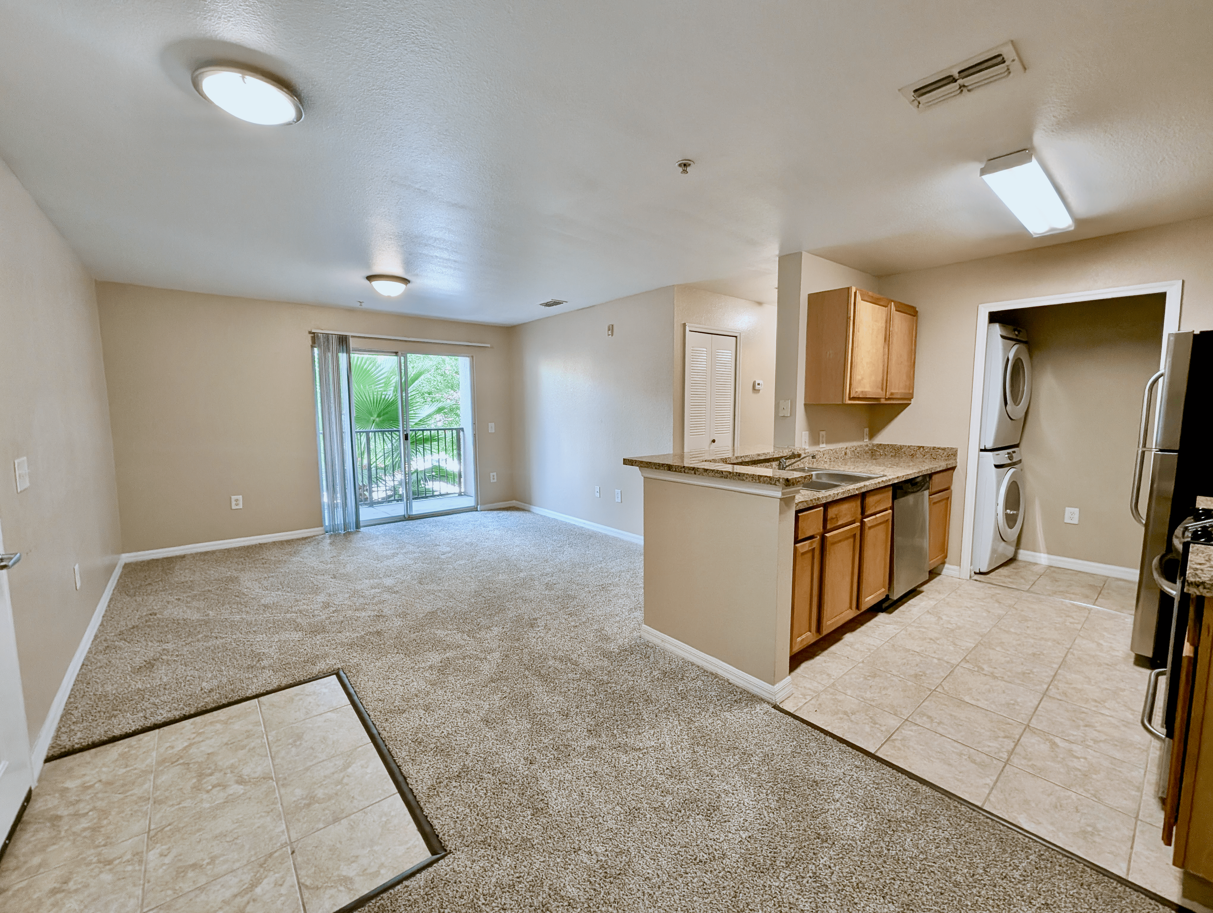 Bright and spacious apartment with an open-concept living area, modern kitchen, and large windows leading to a serene balcony view.
