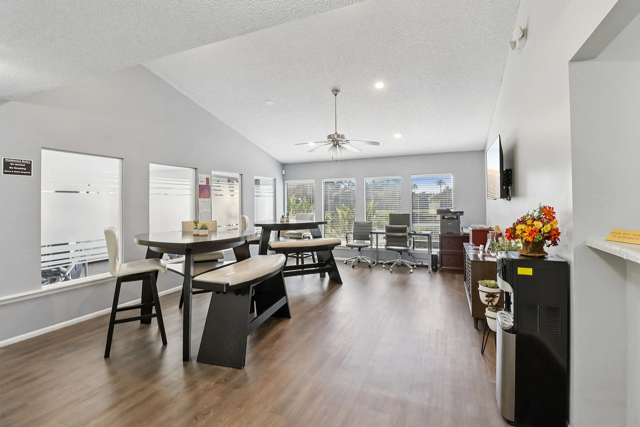 Bright and modern community room with sleek furniture, large windows, and stylish wood flooring, perfect for gatherings and relaxation.
