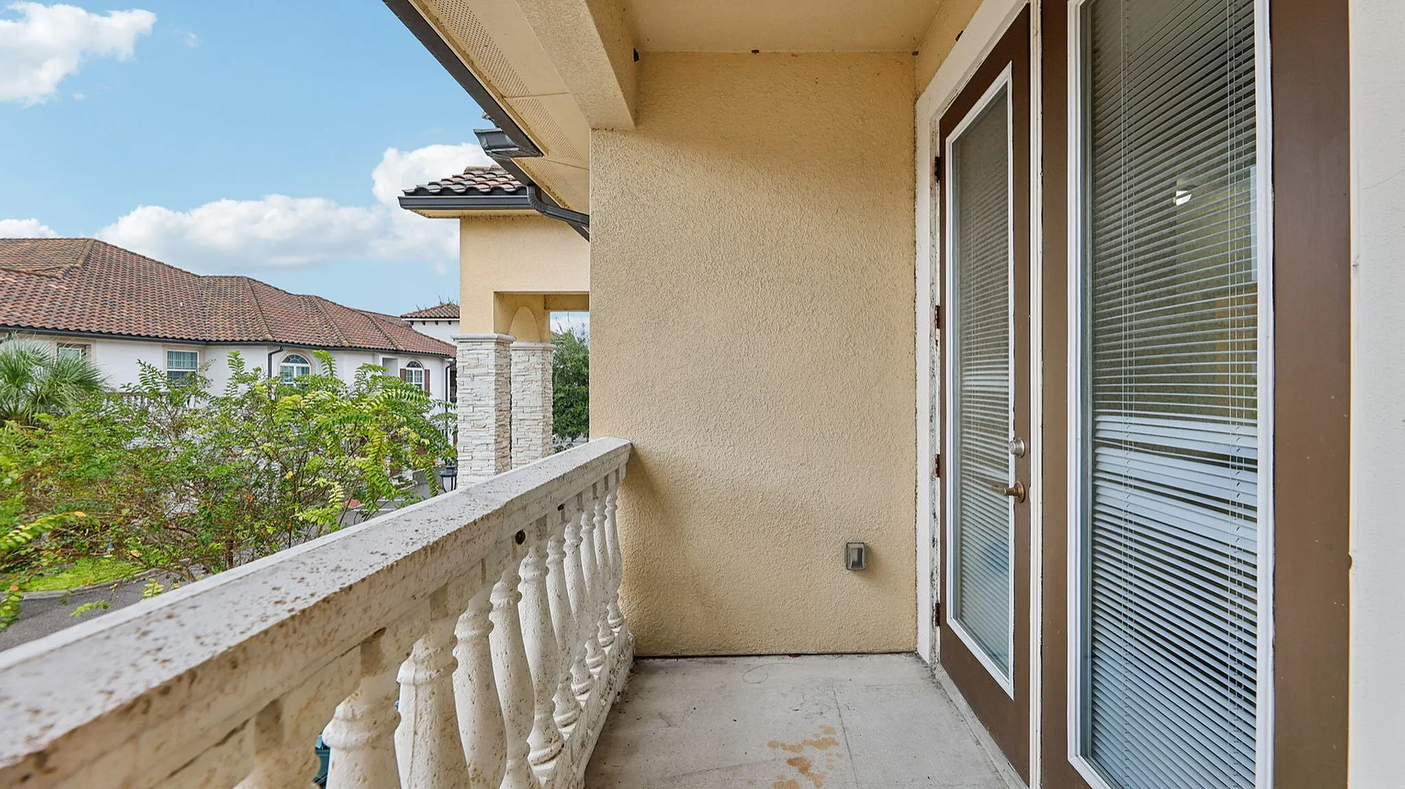 Charming balcony with elegant railing offering a scenic view and abundant natural light, ideal for relaxation.