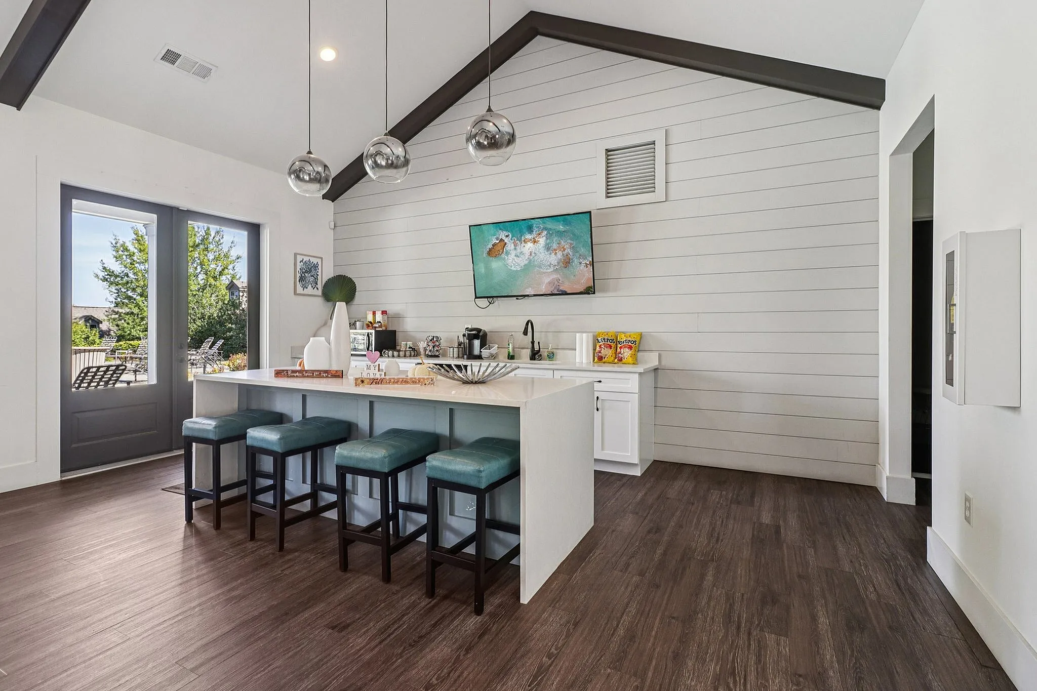 Chic modern kitchen with a breakfast bar, stylish pendant lighting, and vibrant outdoor views.