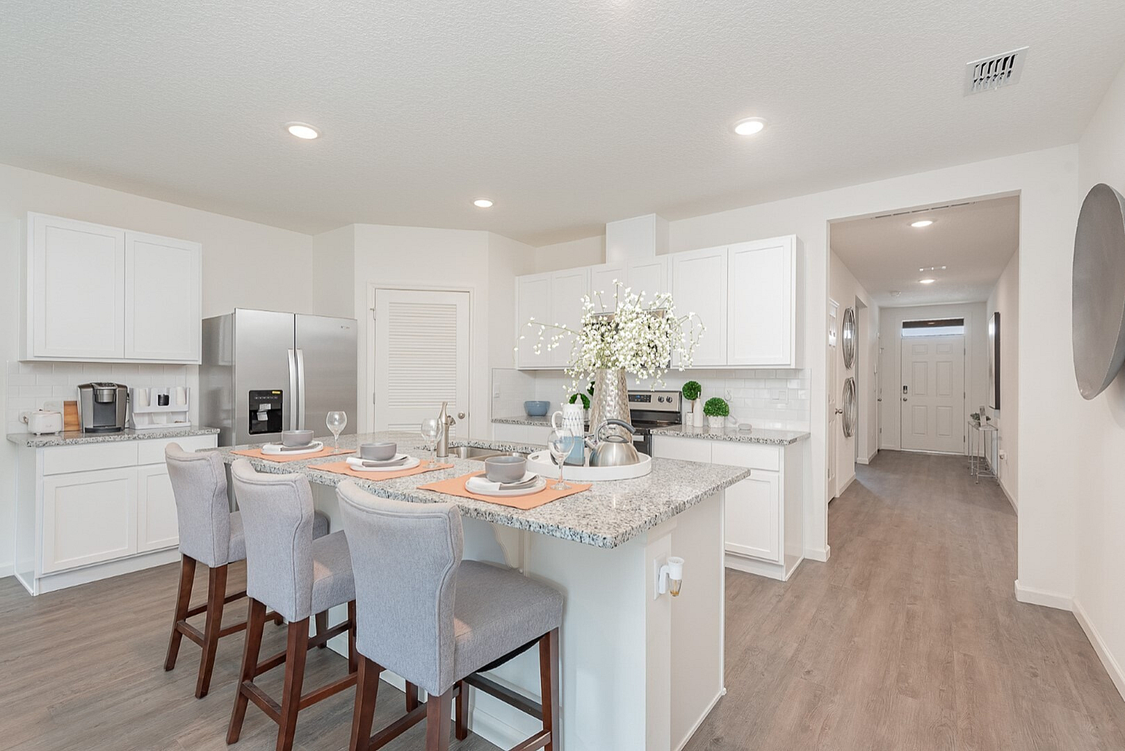Bright and modern kitchen featuring sleek granite countertops, stainless steel appliances, and inviting breakfast bar with stylish seating.