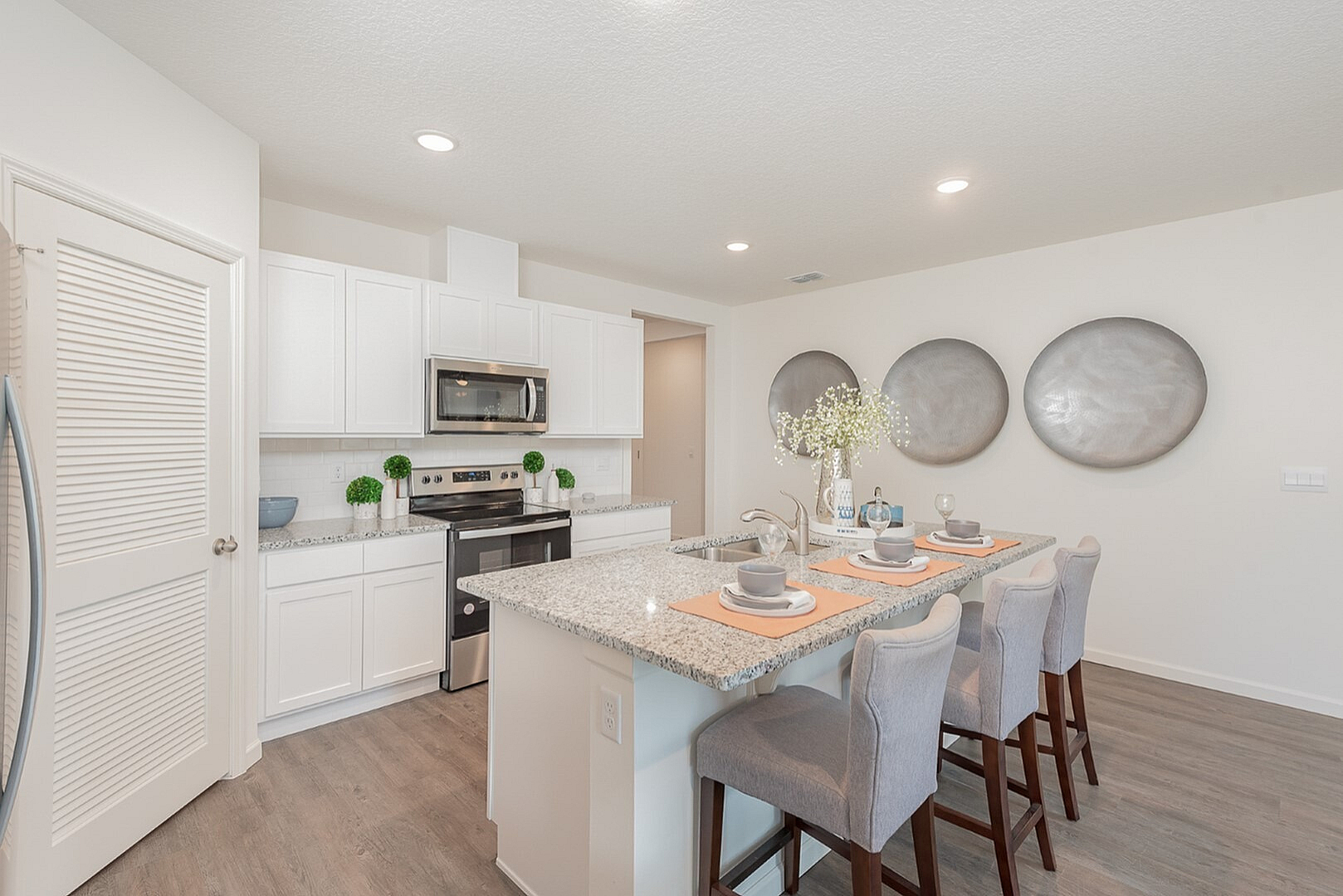 Chic modern kitchen with granite countertops, elegant bar seating, and sleek stainless steel appliances.