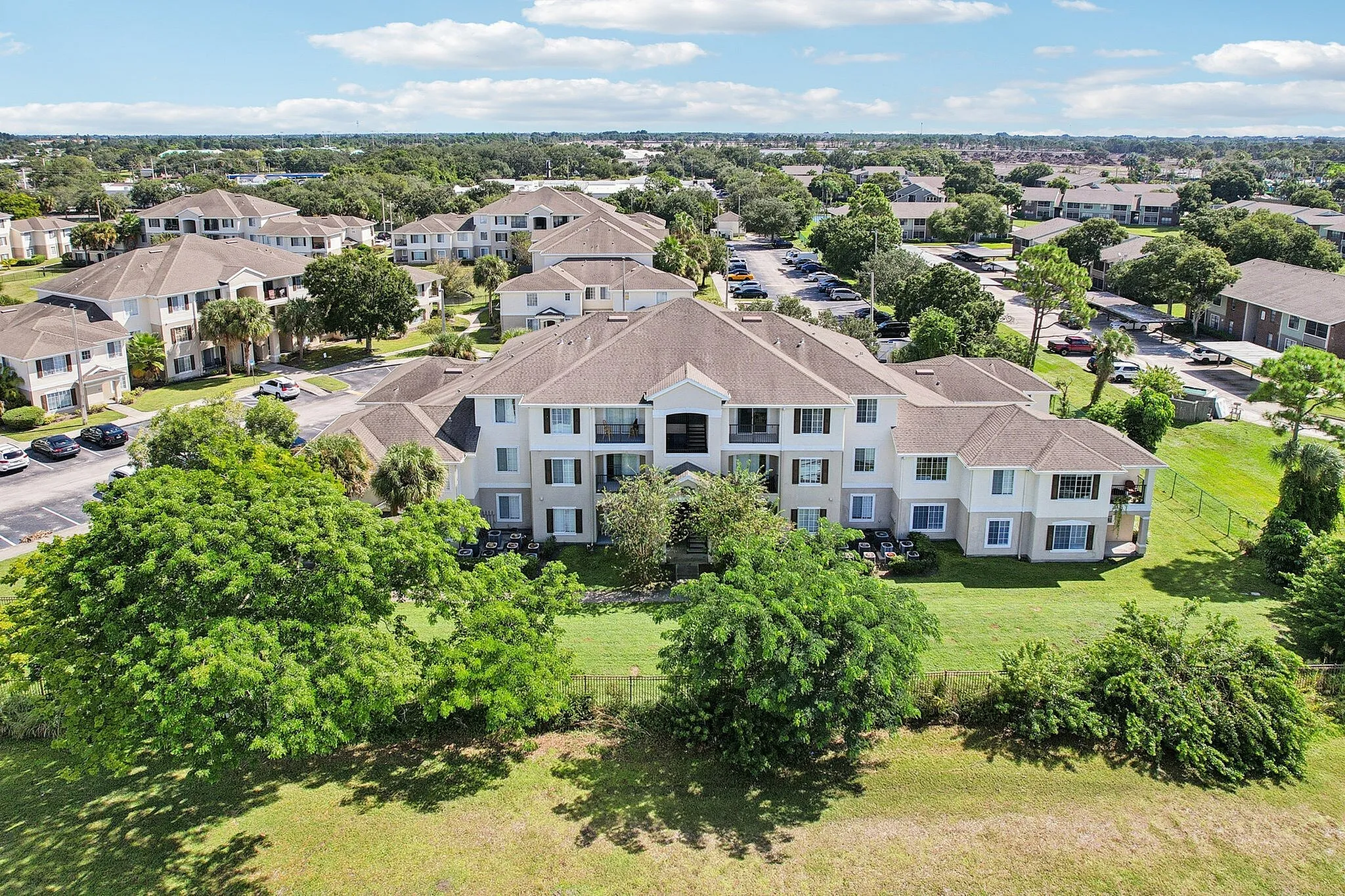 Charming apartment complex surrounded by lush greenery, featuring modern architecture and spacious layouts, ideal for serene living.