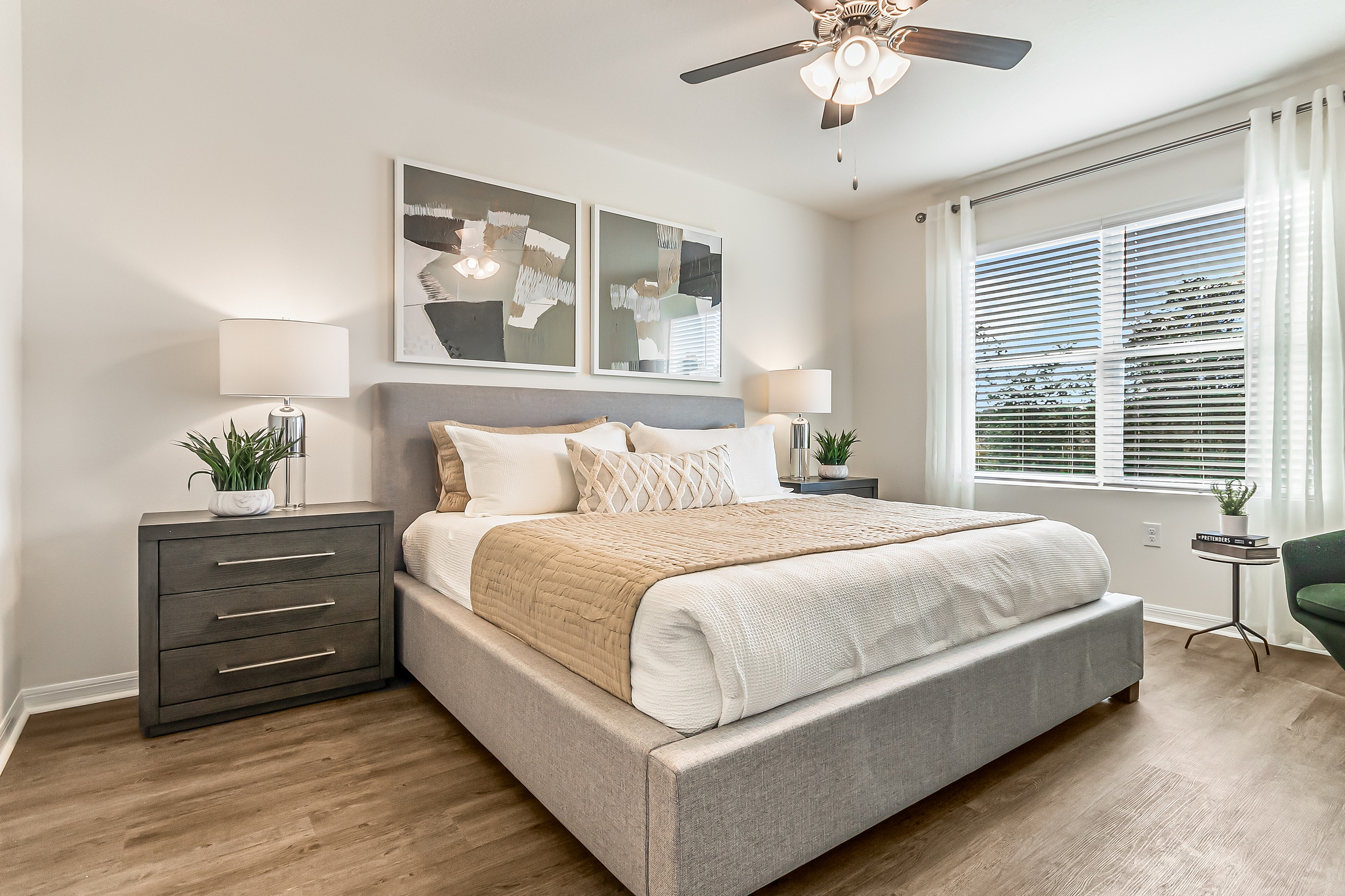 Bright and inviting bedroom featuring a plush, modern bed with elegant decor and ample natural light through large windows.