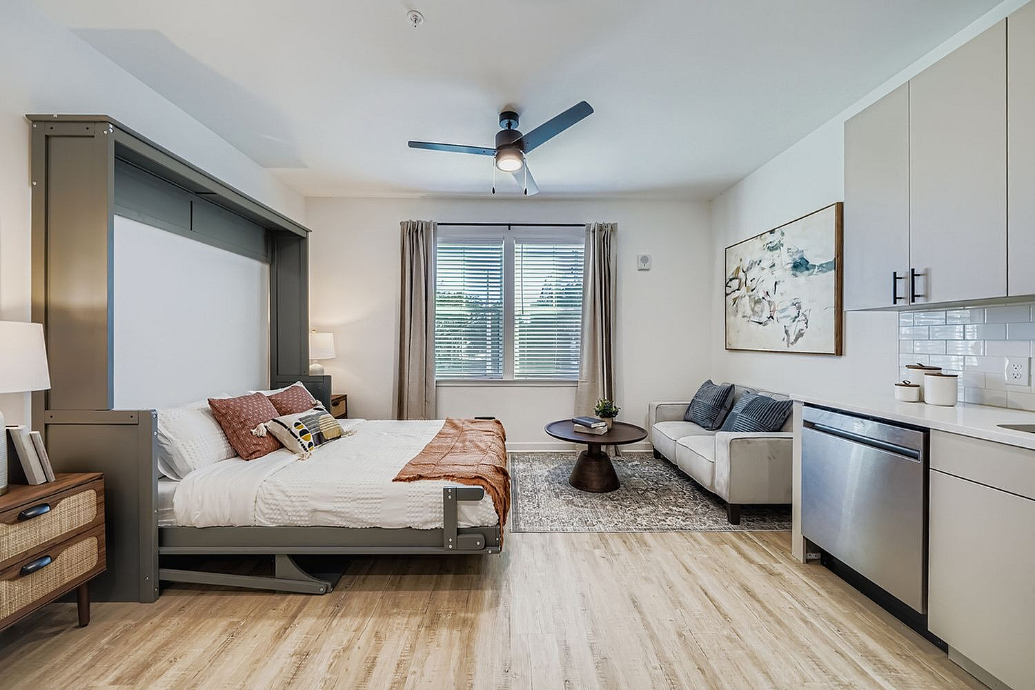 Charming studio apartment options featuring a stylish Murphy bed, cozy seating area, and modern kitchenette with natural light.