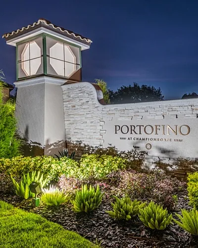 Elegant night view of the Portofino entrance with lush greenery and illuminated signage, creating an inviting and serene atmosphere.