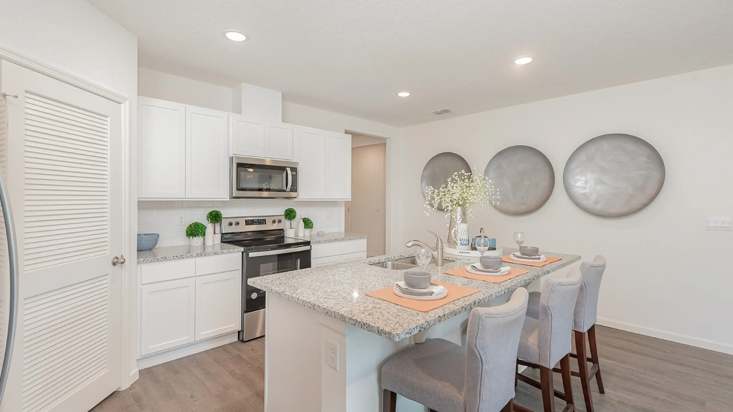 Modern kitchen with sleek granite countertops, stylish bar seating, and contemporary decor, perfect for entertaining.
