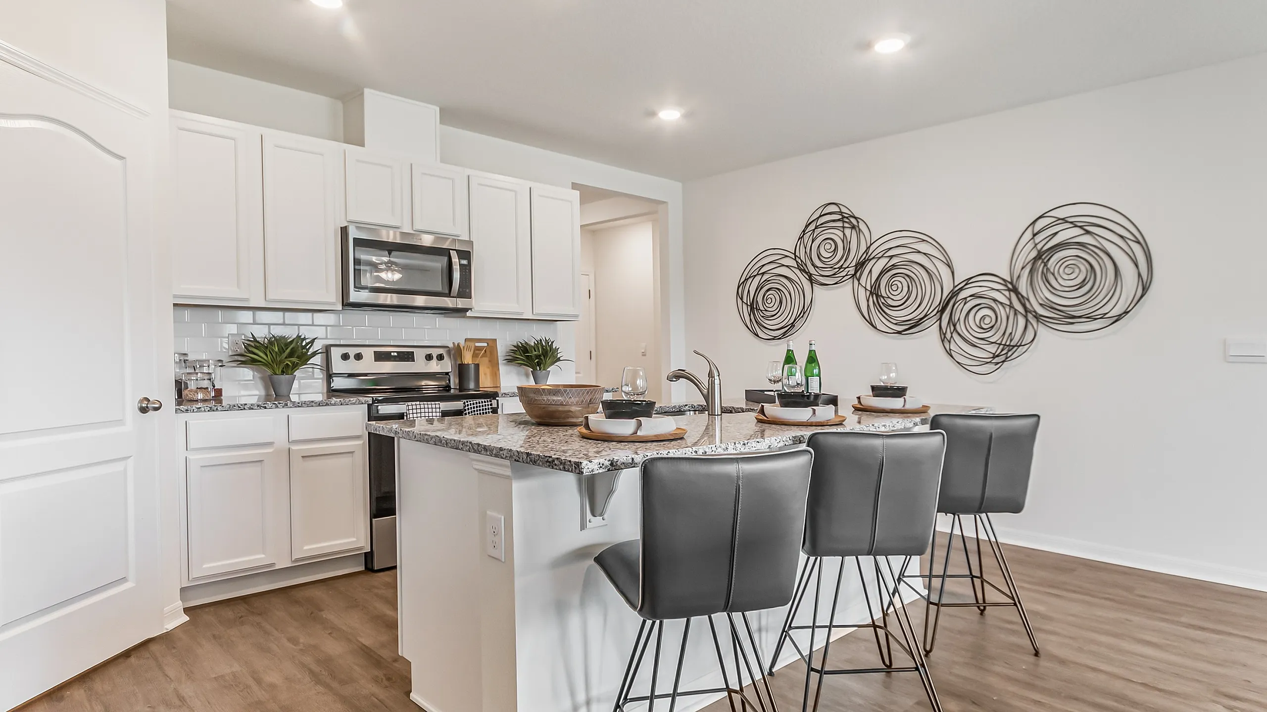 Modern kitchen with chic bar seating, granite countertops, and stainless steel appliances, perfect for entertaining.