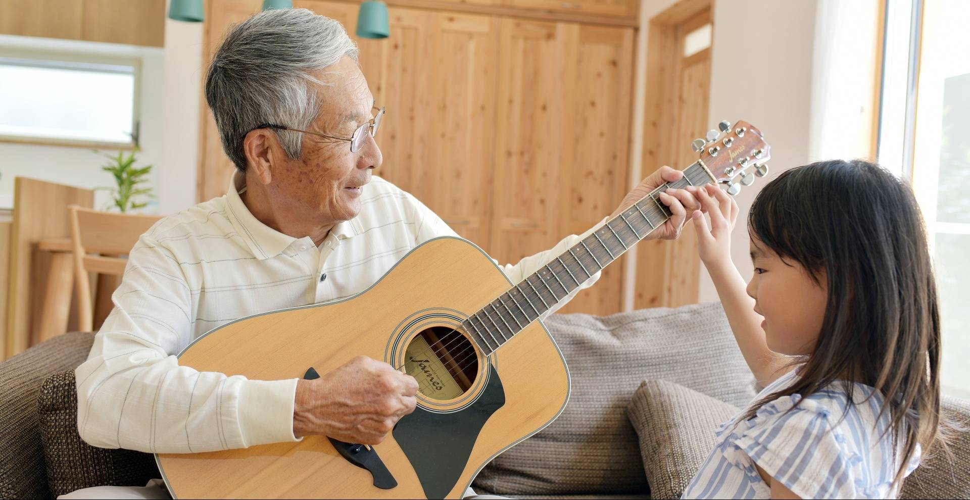 grandfather playing guitar for granddaughter