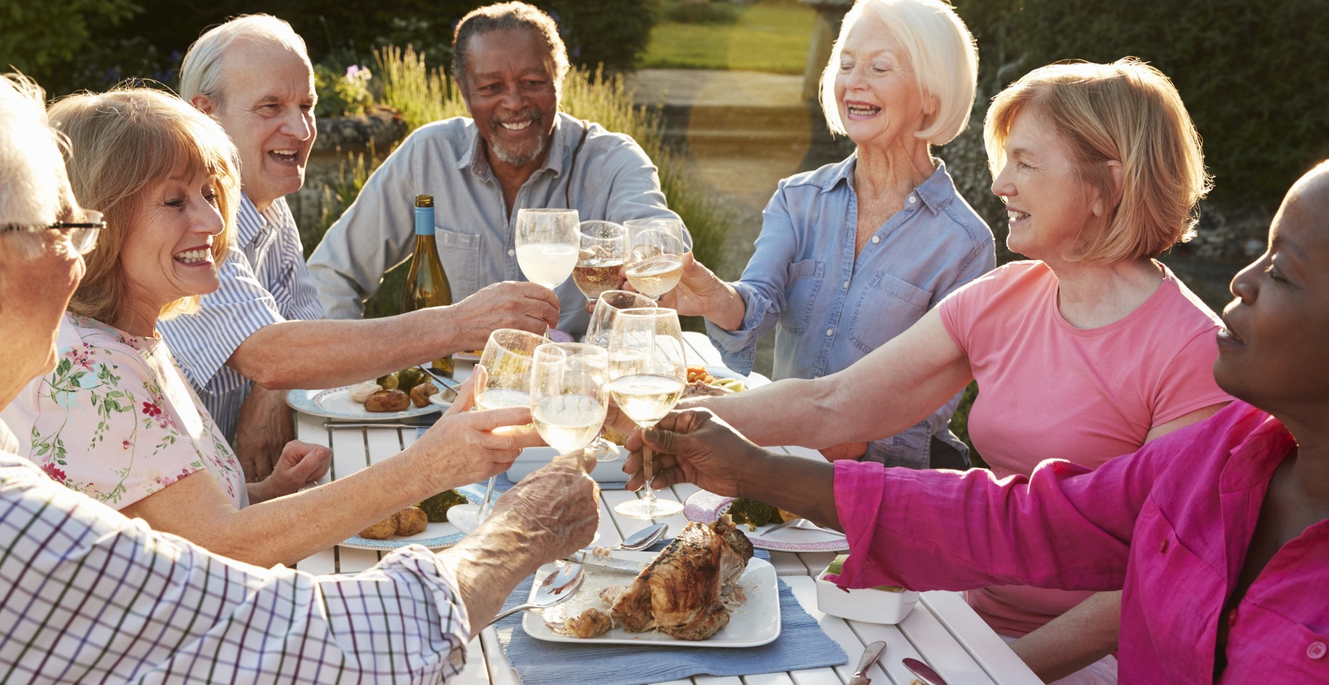 55+ Seniors Toasting And Eating An Beautiful Afternoon Dinner