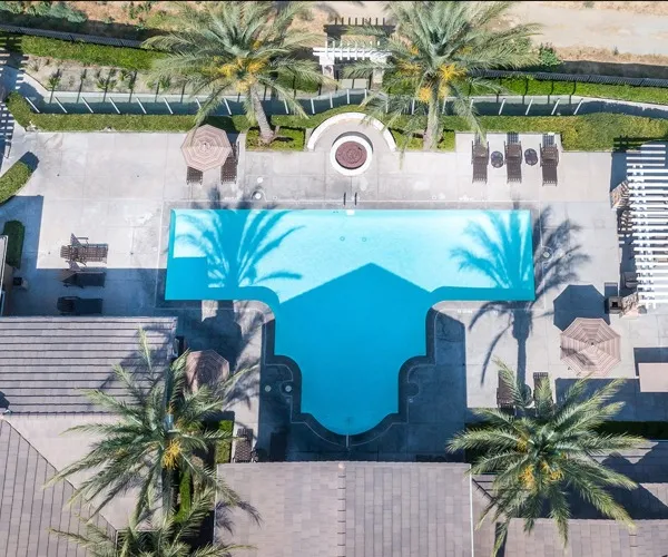 Aerial view of Elate Rancho Cucamonga Apartments in Rancho Cucamonga, CA, featuring a swimming pool and palm trees.