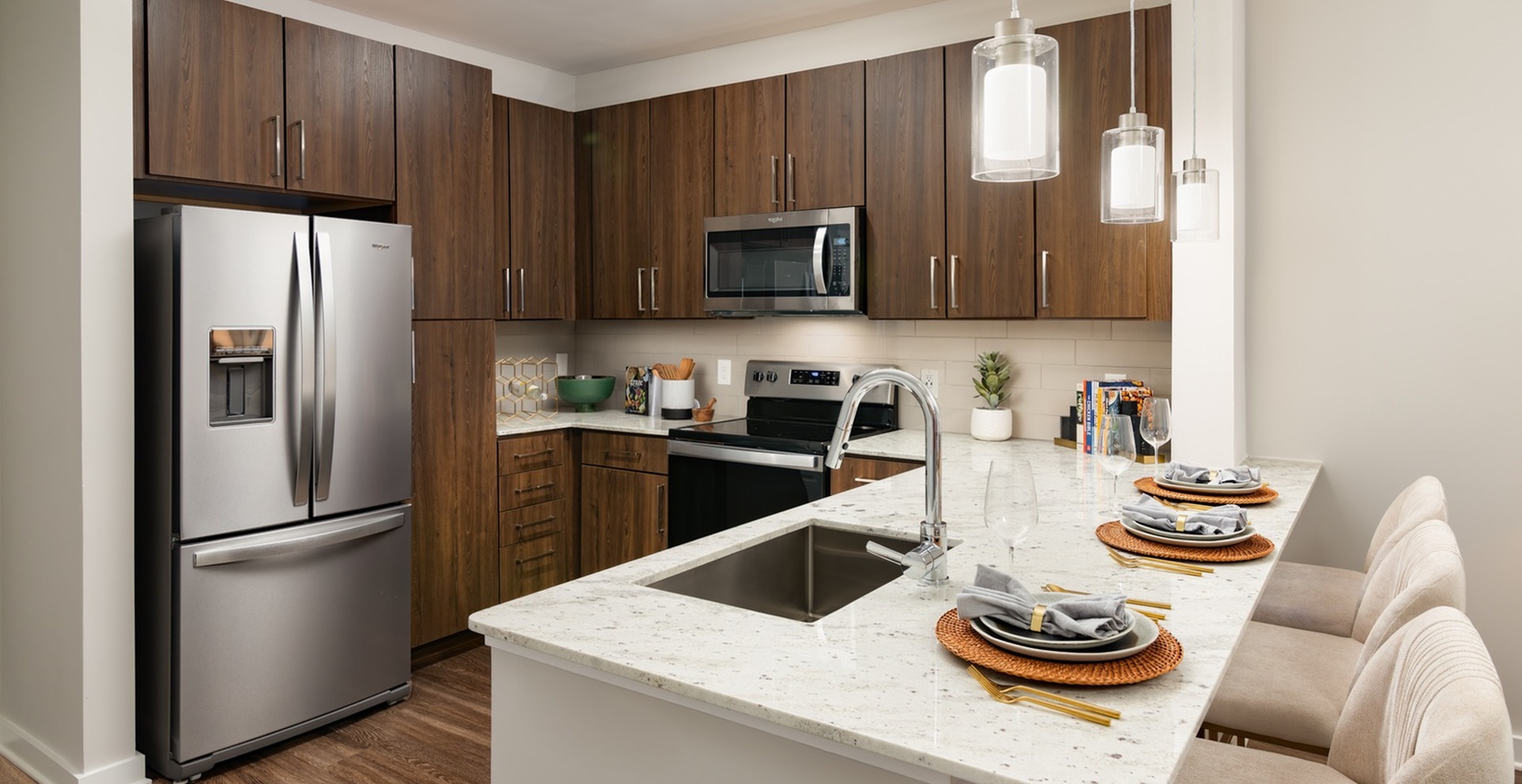 kitchen with fridge, cabinets, sink, oven, microwave, plates, barstools