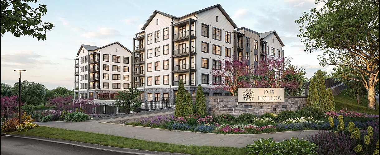 Elegant Fox Hollow apartment complex surrounded by lush landscaping and vibrant gardens, showcasing modern architecture and peaceful suburban charm.