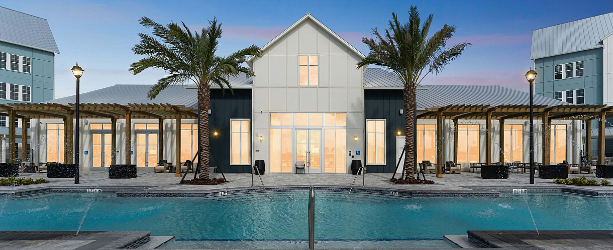 Luxurious poolside retreat with modern architecture, palm trees, and comfortable loungers at sunset.