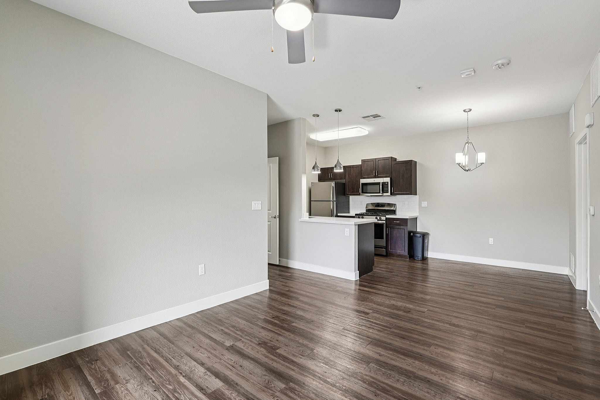 Modern open-concept living area with sleek kitchen and elegant hardwood floors, perfect for contemporary living.