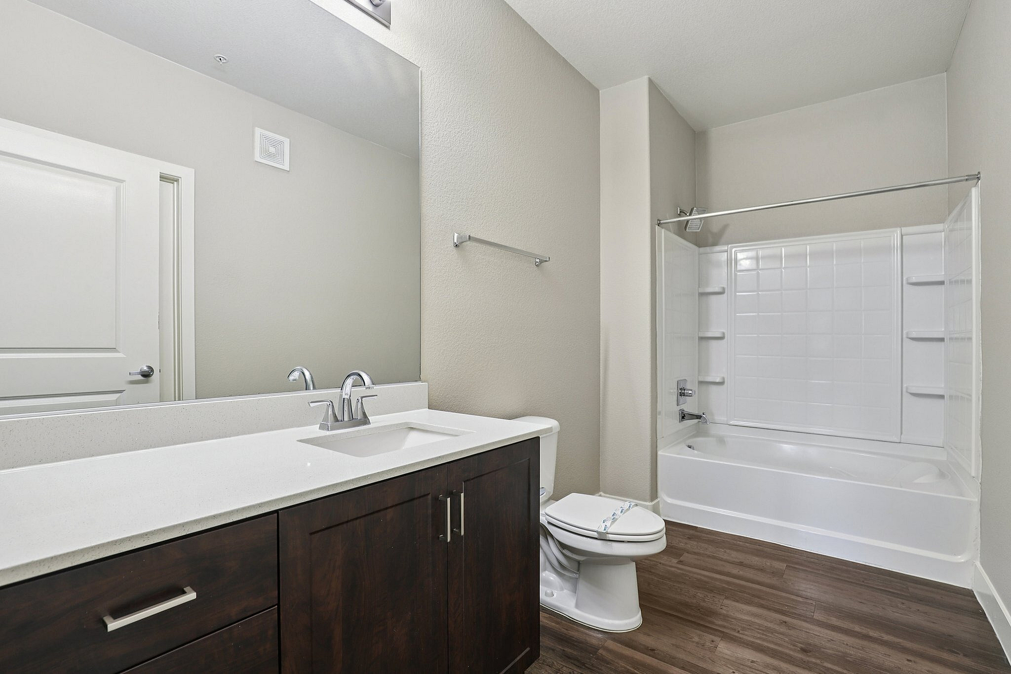 Elegant bathroom featuring a modern vanity, sleek fixtures, and a pristine bathtub with clean tile work.