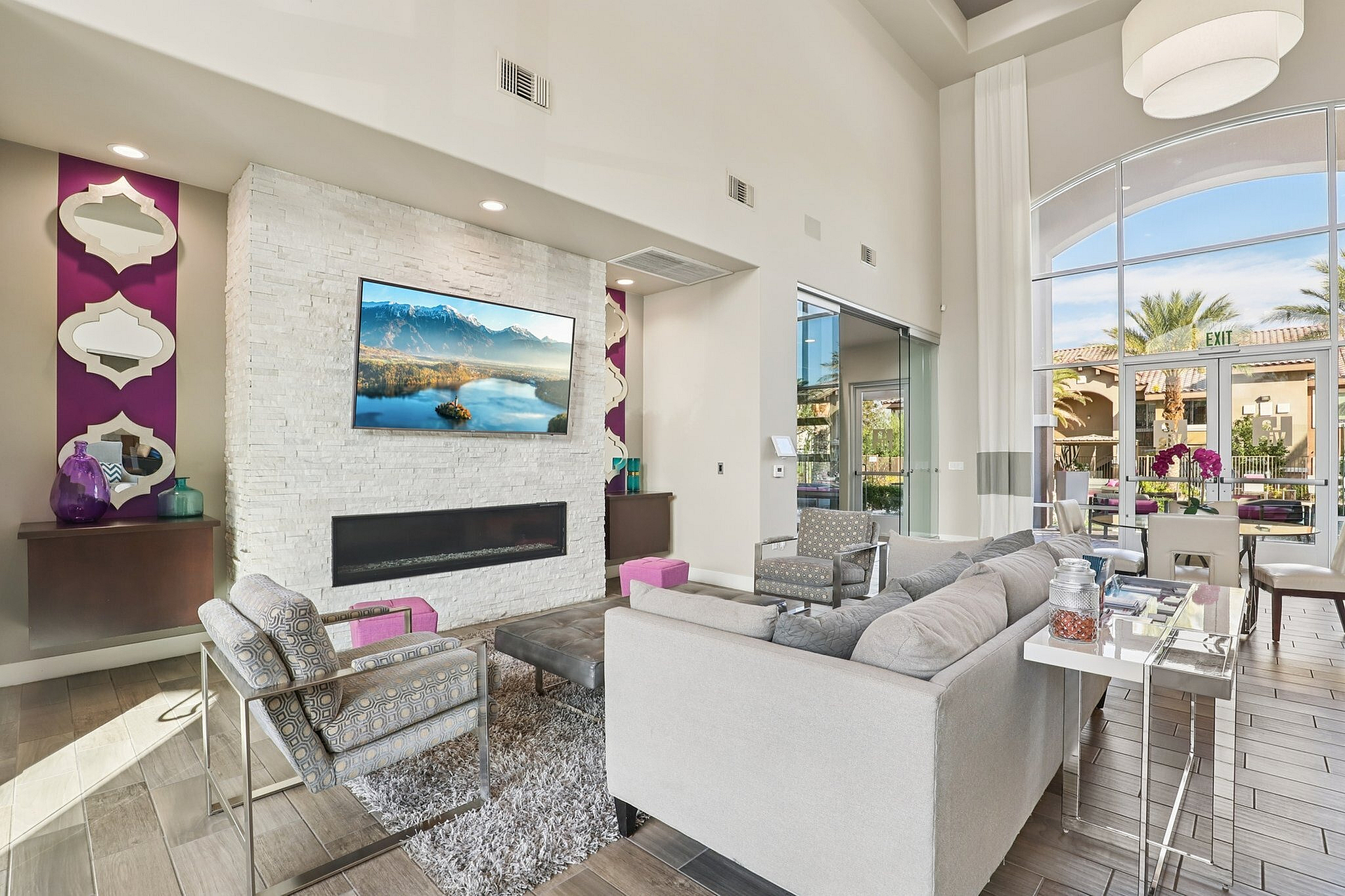 Luxurious living room with high ceilings, featuring modern decor, cozy seating, and expansive windows overlooking a scenic view.