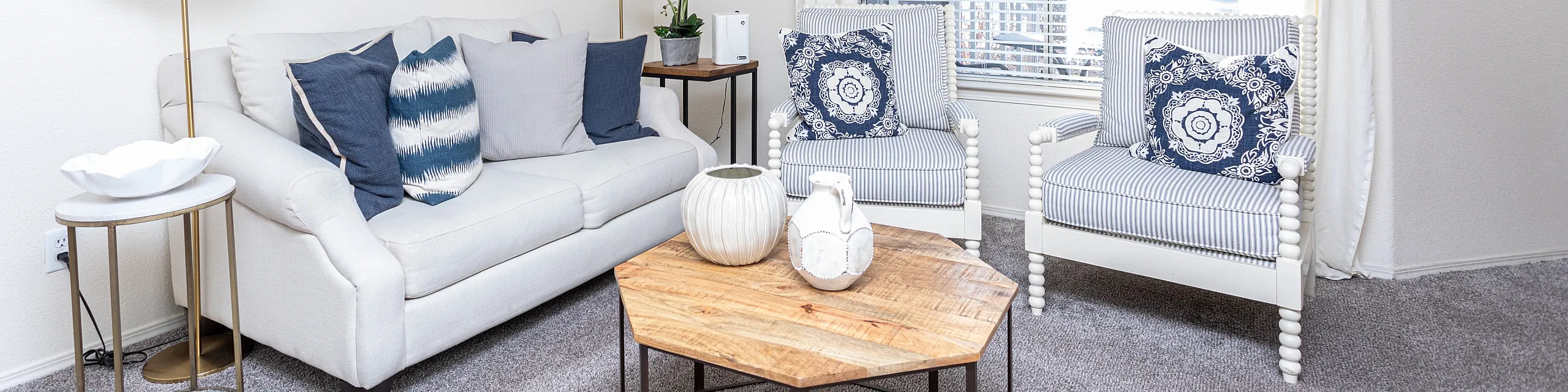 Stylish living room with elegant furniture, decorative pillows, and a wooden coffee table.