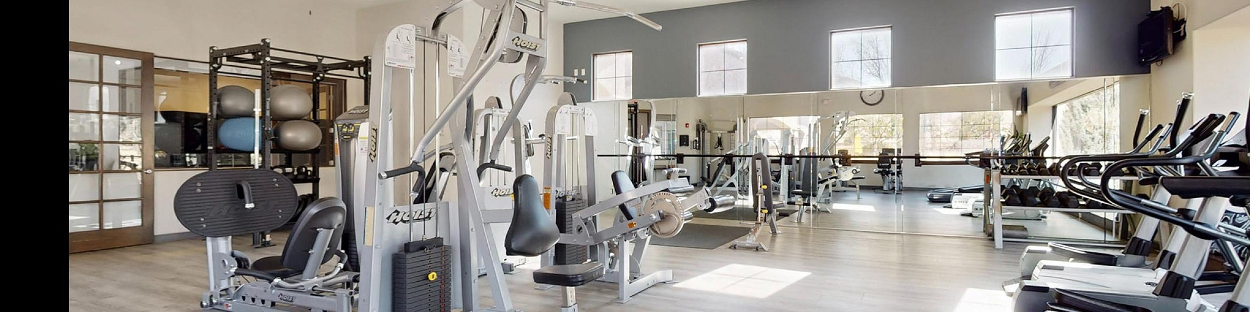Spacious and modern apartment gym with state-of-the-art equipment and bright natural lighting.